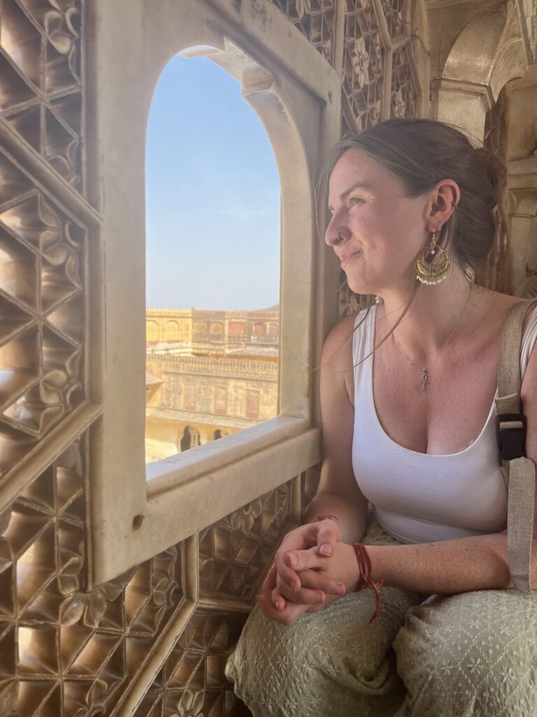 Sally, energy healer and founder of Lush Lunar, looking out of a window at a fort in Rajasthan, India.